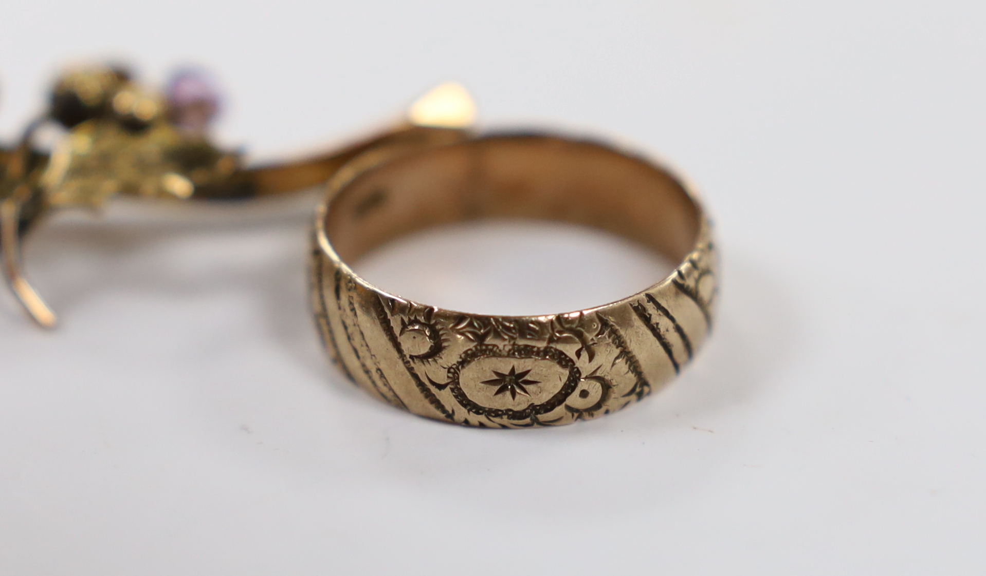 A 9ct and graduated five stone facetted garnet set ring, an engraved 9ct gold band and a 9ct gold and gem set bar brooch (stone missing), gross weight 8.5 grams.